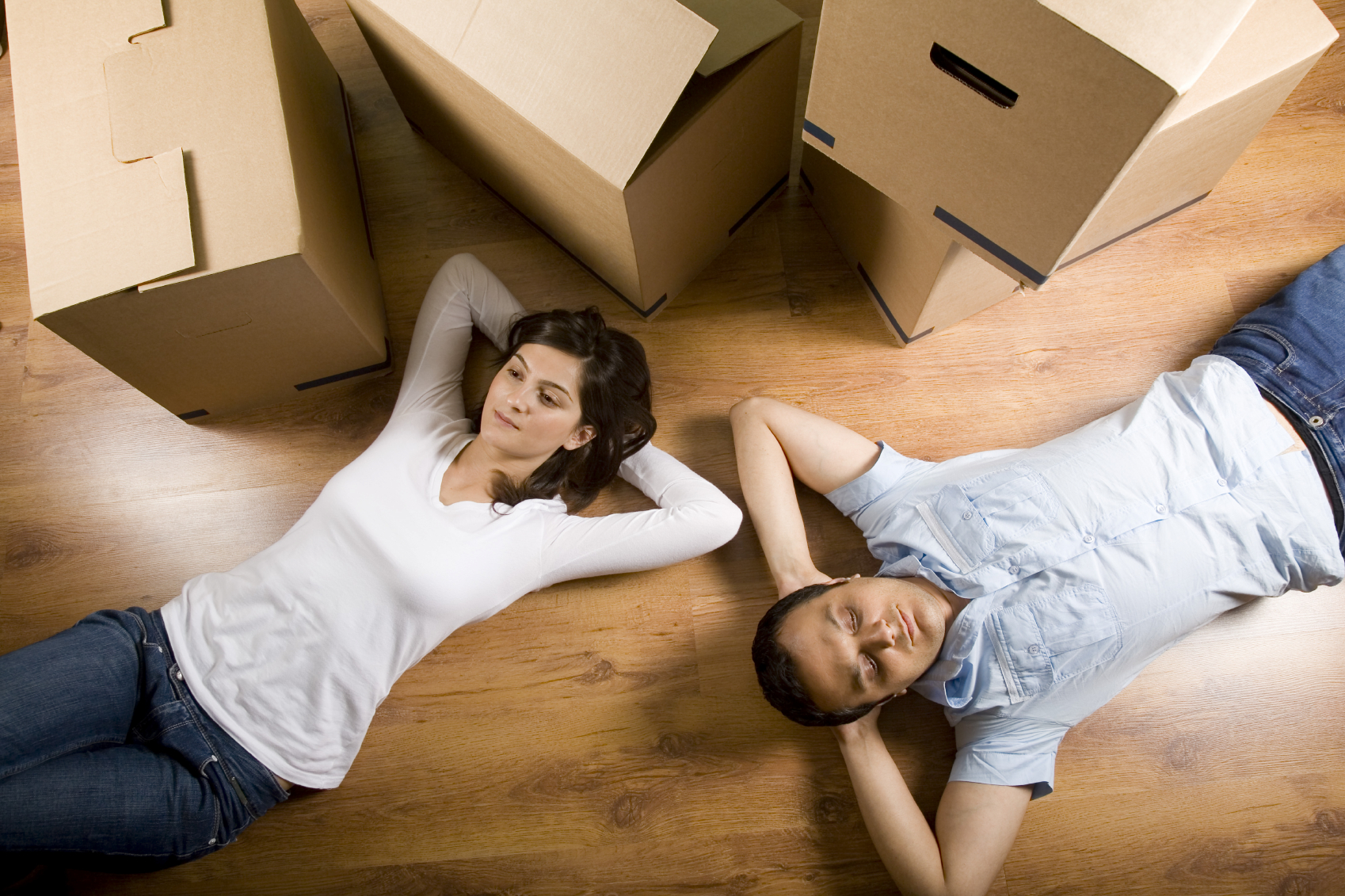 Couple resting after unpacking boxes