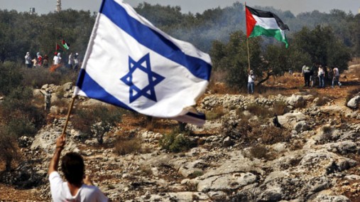 Israeli flag bearer and a Palestinian Flag Bearer in the background