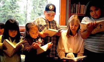 Naskapi child read the Naskapi New Testament Bible aloud with Lana Martens, who began the first translation work in the 1970s. Photo by Pierre Therrien.